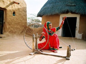 Indische Frau an einem Spinnrad: mit WomenFairTravel begegnen wir Frauen, die uns ihr Handwerk vorstellen