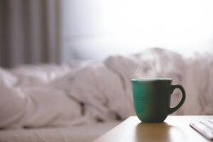 Kaffee neben einem ungemachten Bett. David Mao via Unsplash